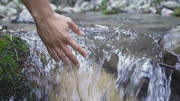 Put one's hand in the stream. Slow motion. video