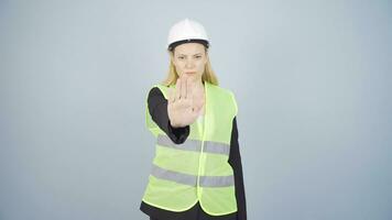 The engineer looks at the camera and makes a stop sign. video