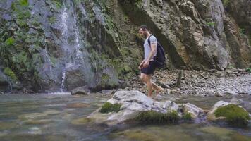 Mann Gehen barfuß sieht aus beim das Wasserfall. video