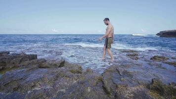 Young man walking in the sea. video