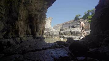 Young man walking on sea cliffs. video