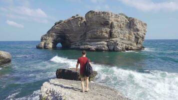 das Mann Aufpassen das Meer auf das Kante von das Cliff. video