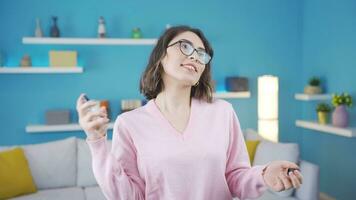 Beautiful young woman sprays perfume and is happy. video