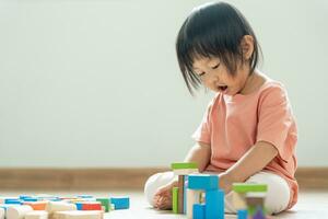 Happy Asian child playing and learning toy blocks. children are very happy and excited at home. child have a great time playing, activities, development, attention deficit hyperactivity disorder photo