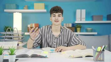 el estudiante estudiando a hogar hace un conferencia por mirando a el cámara. en línea educación. video