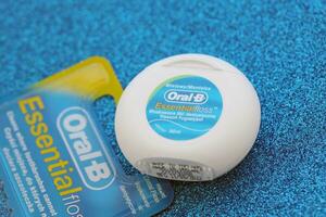 KYIV, UKRAINE - JULY 7, 2023 Oral-B Essentail Floss. Waxed dental floss in round case photo
