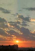 Beautiful sunrise with warm orange sunlight and beams through blue sky photo