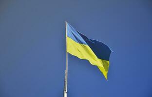 Ukrainian flag against the blue cloudless sky. The official flag of the Ukrainian state includes yellow and blue colors photo