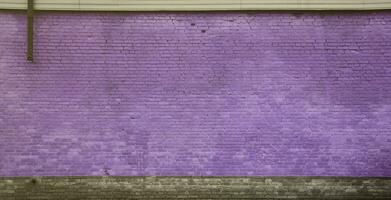 The texture of the brick wall of many rows of bricks painted in violet color photo