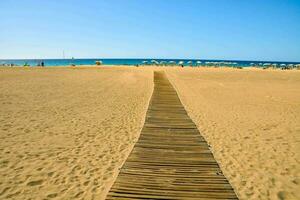 un madera camino en el playa foto