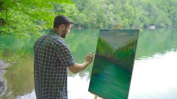 talentoso pintor quem tintas uma lago panorama. video