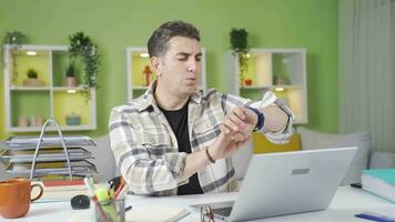 casa ufficio lavoratore guardare a il suo orologio prende agitato e panico. video