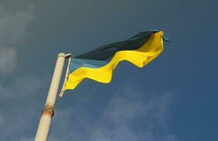 Ukraine flag large national symbol fluttering in blue sky. Large yellow blue Ukrainian state flag, Dnipro city, Independence Constitution Day photo