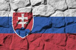 Slovakia flag depicted in paint colors on old stone wall closeup. Textured banner on rock wall background photo