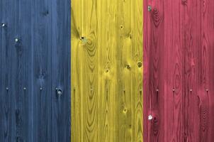 Chad flag depicted in bright paint colors on old wooden wall. Textured banner on rough background photo