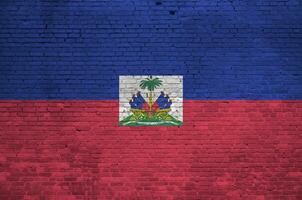 Haití bandera representado en pintar colores en antiguo ladrillo pared. texturizado bandera en grande ladrillo pared albañilería antecedentes foto