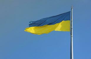 Ukrainian flag isolated on the blue sky with clipping path. Close up waving banner of Ukraine. Tall flag symbol of Ukraine, european country photo