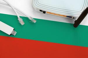 Bulgaria flag depicted on table with internet rj45 cable, wireless usb wifi adapter and router. Internet connection concept photo