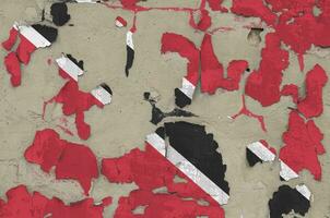 Trinidad and Tobago flag depicted in paint colors on old obsolete messy concrete wall closeup. Textured banner on rough background photo