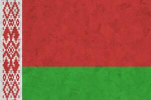 Belarus flag depicted in bright paint colors on old relief plastering wall. Textured banner on rough background photo