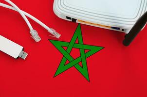 Marruecos bandera representado en mesa con Internet rj45 cable, inalámbrico USB Wifi adaptador y enrutador Internet conexión concepto foto
