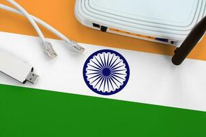 India flag depicted on table with internet rj45 cable, wireless usb wifi adapter and router. Internet connection concept photo