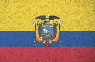 Ecuador flag depicted in bright paint colors on old relief plastering wall. Textured banner on rough background photo
