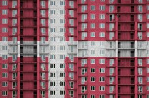 Denmark flag depicted in paint colors on multi-storey residental building under construction. Textured banner on brick wall background photo