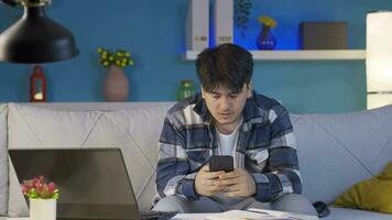 The man who texts on the phone at home at night is disappointed. video