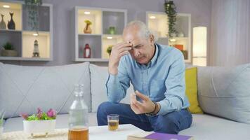 Thoughtful man with wedding ring in hand drinking alcohol. video