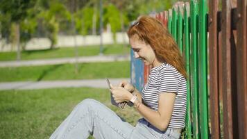 Young woman with money is sitting outdoors and is happy. video