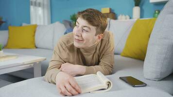 joven hombre teniendo un bueno hora leyendo un libro. contento joven hombre. video