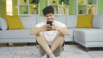 Happy and cheerful young man texting on the phone. video