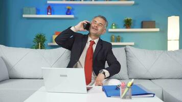 Home office worker man talking on the phone happily. video