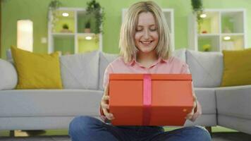 Jeune fille ouverture cadeau envelopper. video