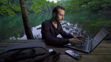 Businessman working with his laptop in nature. video