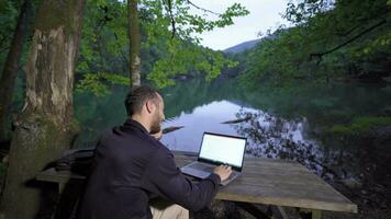 homme d'affaire parlant par téléphone contre le lac. video