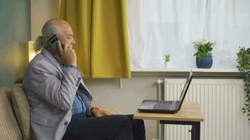 The man talking on the phone is cold next to the cold heater. video