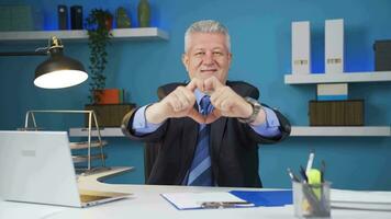 Loving businessman making heart symbol at camera. video