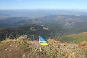 Ukrainian flag on top of Hoverla mountain in Ukraine photo