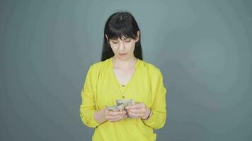 Woman counting money looking at camera. video