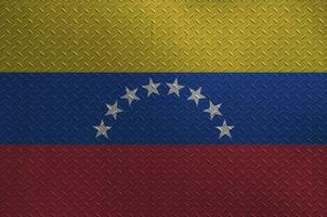 Venezuela flag depicted in paint colors on old brushed metal plate or wall closeup. Textured banner on rough background photo