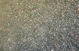 Close up of muddy puddle with small stones on wet surface. Background texture with top view photo