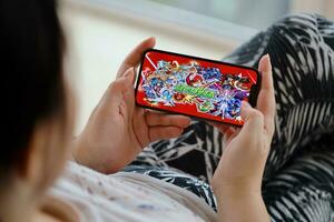 Monster Strike mobile iOS game on iPhone 15 smartphone screen in female hands during mobile gameplay photo