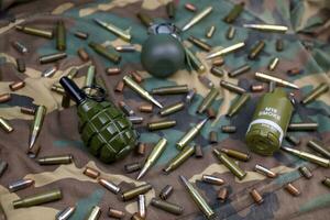 Different types of ammunition on a camouflage background. Preparing for war photo