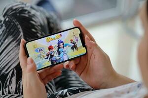 Fantasy Westward Journey mobile iOS game on iPhone 15 smartphone screen in female hands during mobile gameplay photo