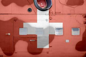 Switzerland flag depicted on side part of military armored helicopter closeup. Army forces aircraft conceptual background photo