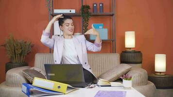 Home office worker woman dances looking at camera. video