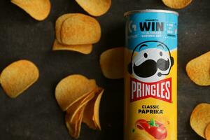 KYIV, UKRAINE - 4 MAY, 2023 Pringles tube of chips with rare classic paprika flavour photo