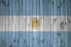argentina bandera representado en brillante pintar colores en antiguo de madera pared. texturizado bandera en áspero antecedentes foto